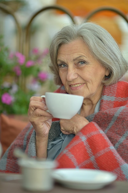 Hermosa mujer senior sonriente bebiendo té