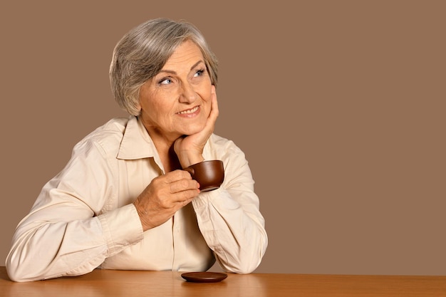Hermosa mujer senior sonriente bebiendo té