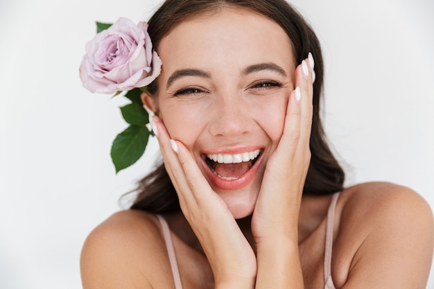 Hermosa mujer sensual joven sonriente vistiendo traje aislado, posando con una flor