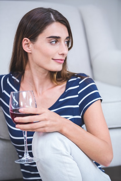 Hermosa mujer sentada con una copa de vino tinto