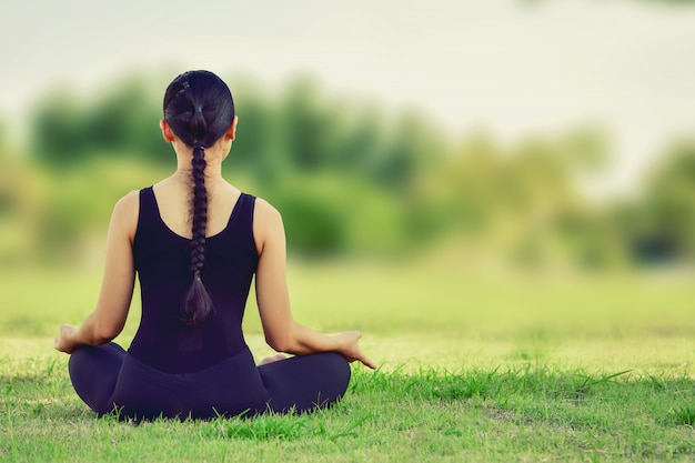 Hermosa mujer sentada en posturas de yoga para un ejercicio equilibrado del cuerpo.