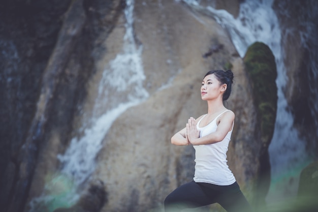 Hermosa mujer sentada y practicando yoga.