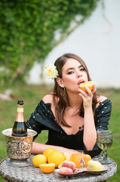 Hermosa mujer sexy en el jardín comiendo frutas tropicales vacaciones de verano hermosa mujer comiendo naranja e