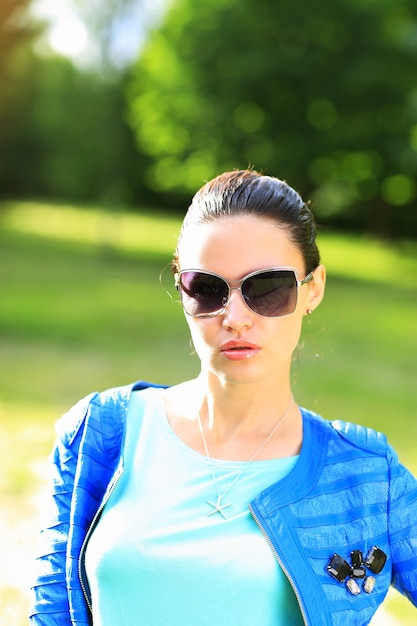 Hermosa mujer sexy en la naturaleza en gafas de sol negras