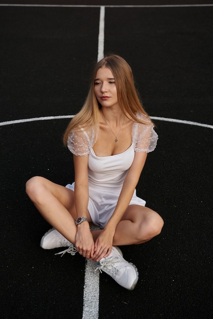 Hermosa mujer sexy posando al aire libre en la calle, joven y bella mujer en la cancha de baloncesto.