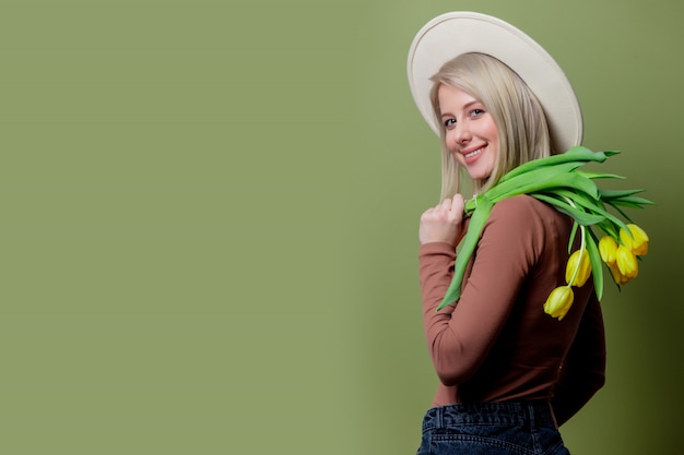 Hermosa mujer con un sombrero con ramo de tulipanes