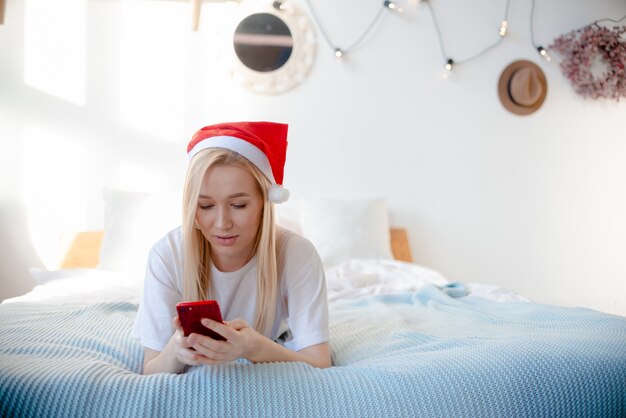 Hermosa mujer con un sombrero de santa sonriendo. Mujer con regalos vista horizontal presenta y concepto de celebración.