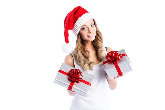 Hermosa mujer con sombrero de santa sonrisa sosteniendo un elegante dos cajas con regalos aislados.