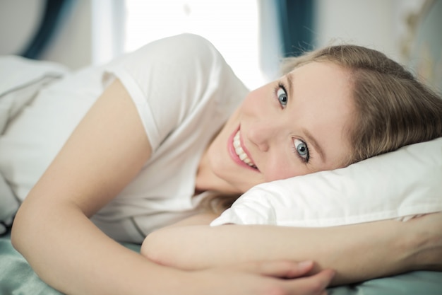 Hermosa mujer sonriendo en la cama