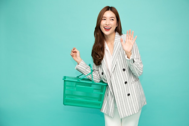 Hermosa mujer sonriendo y sosteniendo la cesta de la compra