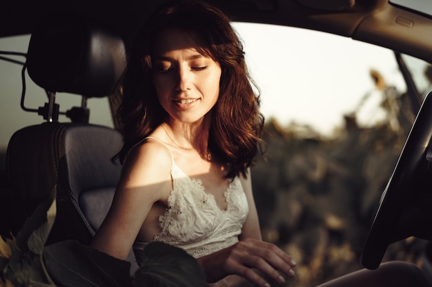 Hermosa mujer sonriente conduciendo su coche por la mañana