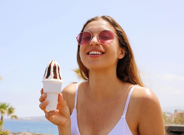 Hermosa mujer sonriente con gafas de sol en la playa