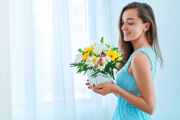 Hermosa mujer sonriente joven feliz alegre caucásica con flor fresca brillante colorida decorativa