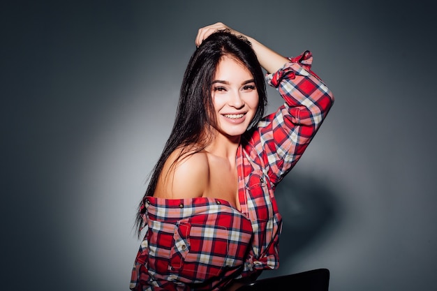 Hermosa mujer sonriente con maquillaje natural, piel limpia y dientes blancos sobre fondo gris, ¡vistiendo en casual!