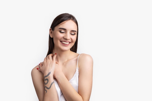 Hermosa mujer sonriente con maquillaje natural de piel limpia y dientes blancos sobre un fondo gris