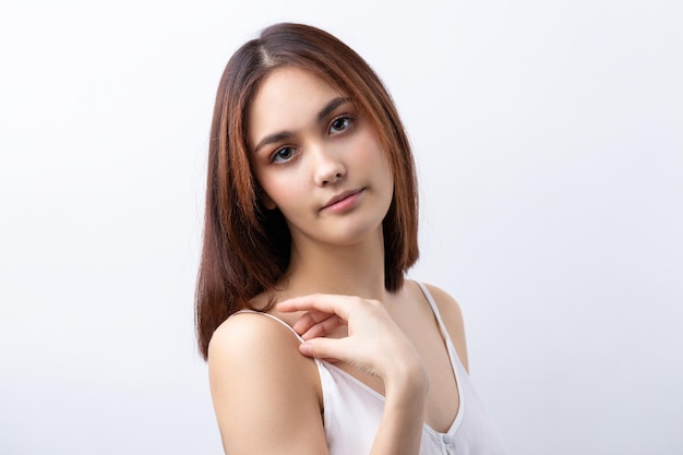 Hermosa mujer sonriente con maquillaje natural de piel limpia y dientes blancos sobre un fondo gris