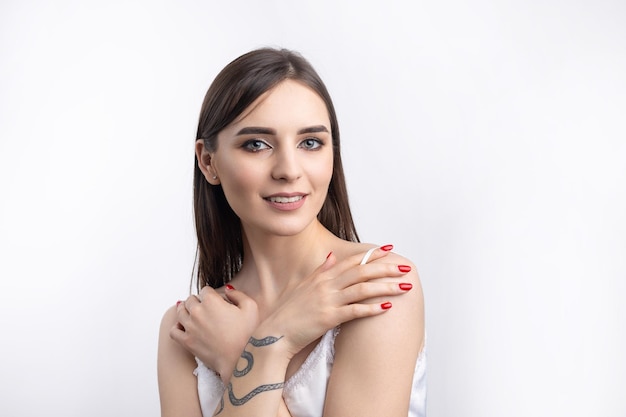 Hermosa mujer sonriente con maquillaje natural de piel limpia y dientes blancos sobre un fondo gris