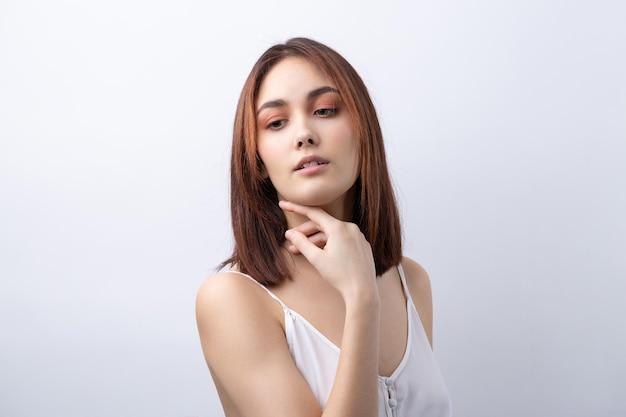 Hermosa mujer sonriente con maquillaje natural de piel limpia y dientes blancos sobre un fondo gris