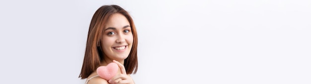 Hermosa mujer sonriente con maquillaje natural de piel limpia y dientes blancos sobre un fondo gris