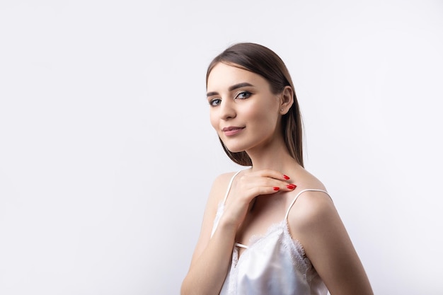 Hermosa mujer sonriente con maquillaje natural de piel limpia y dientes blancos sobre un fondo gris