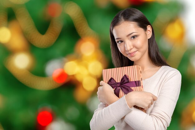 Hermosa mujer sonriente con el pelo largo con caja de regalo