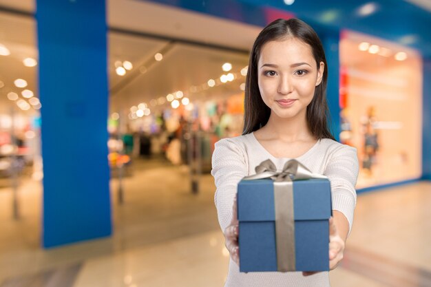 Hermosa mujer sonriente con el pelo largo con caja de regalo