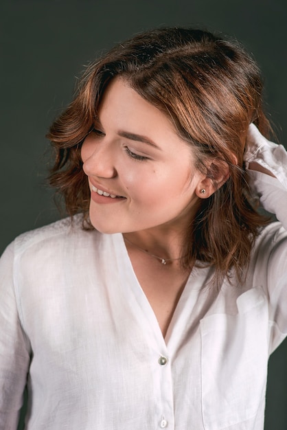 Hermosa mujer sonriente y riendo con cabello castaño corto en el estudio