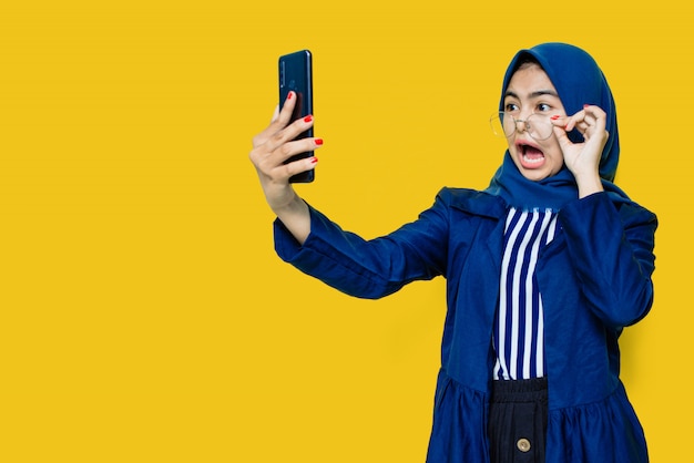 Hermosa mujer sorprendida con gafas y teléfono