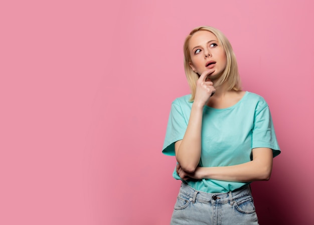 Hermosa mujer sorprendida en pared rosa