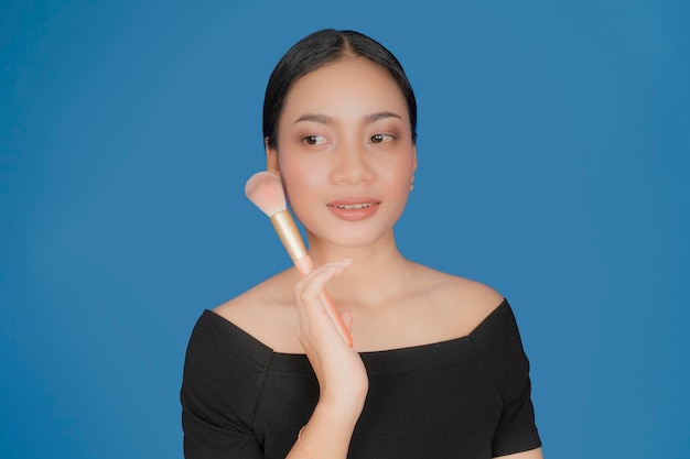 Foto hermosa mujer sostenga el cepillo de maquillaje en polvo cerca de su cara.