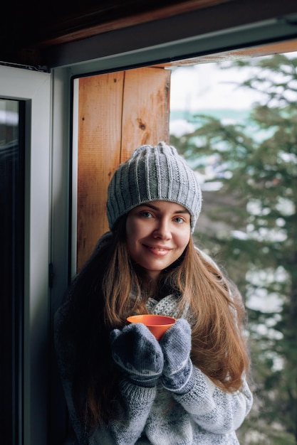 Hermosa mujer sosteniendo y bebiendo una taza de café