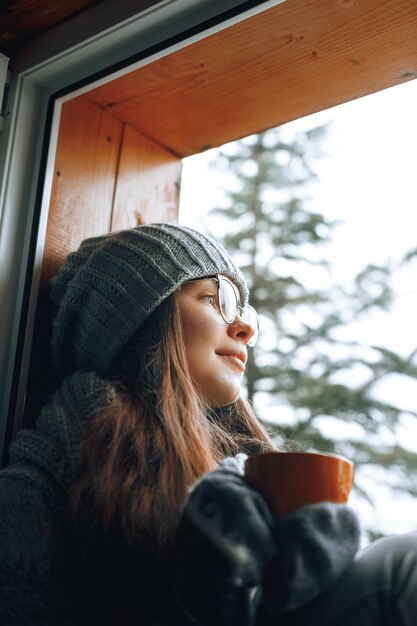 Hermosa mujer sosteniendo y bebiendo una taza de café