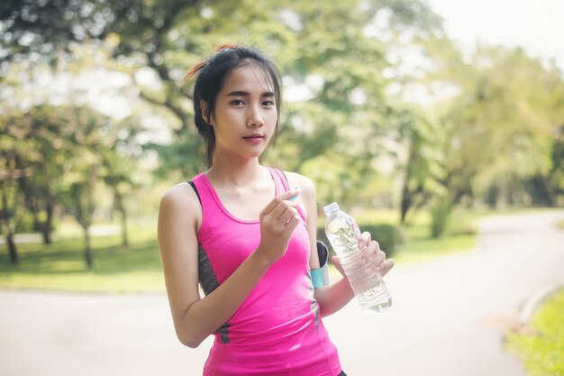 Hermosa mujer sosteniendo una botella de agua después de correr.