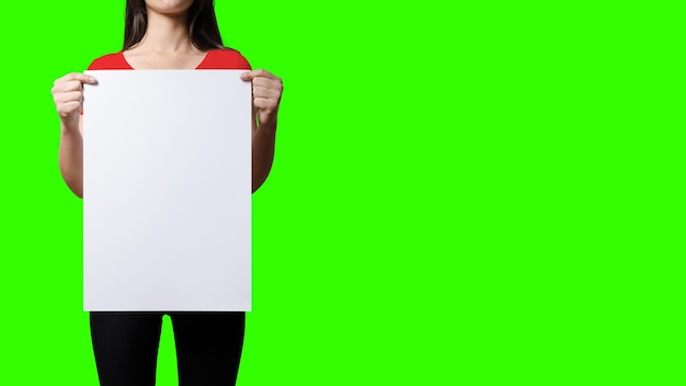 Hermosa mujer sosteniendo un letrero en blanco en el fondo de la pantalla verde adecuado para su proyecto de elemento, agregó espacio de copia para el texto