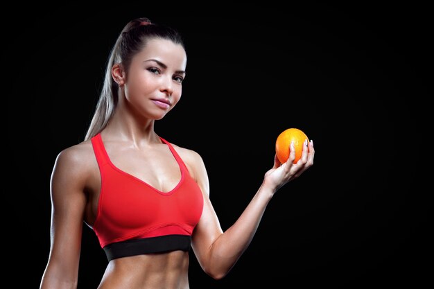 Hermosa mujer sosteniendo una naranja