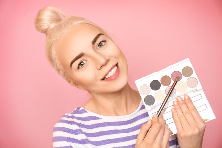 Foto hermosa mujer sosteniendo paleta de sombras de ojos coloridas