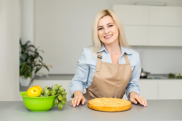 Hermosa mujer sosteniendo pastel en la cocina