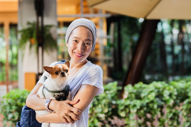 Hermosa mujer sosteniendo perro chihuahua en el jardín al aire libre