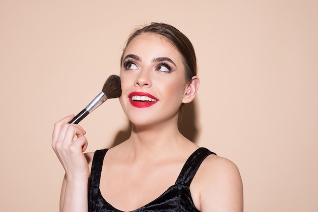 Hermosa mujer sosteniendo pincel de maquillaje Cuidado de la piel femenina primer plano retrato de belleza facial Aplicar tono a la piel