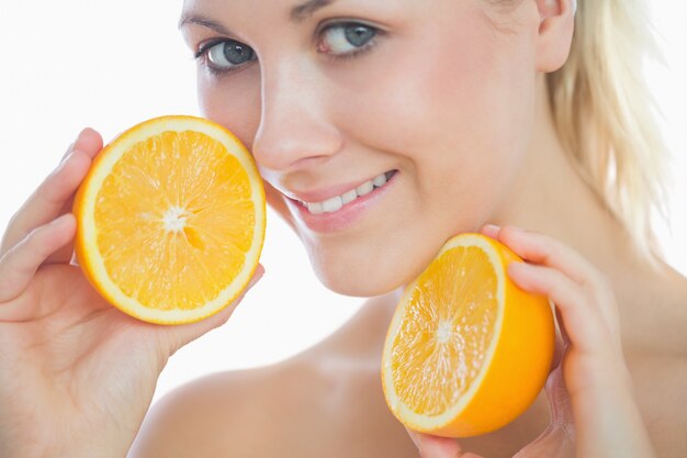 Foto hermosa mujer sosteniendo rodajas de naranja