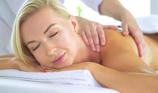 Hermosa mujer spa acostada sobre una toalla en el salón de spa