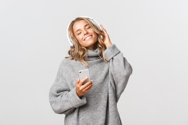 Hermosa mujer en un suéter gris posando