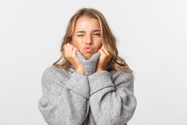 Hermosa mujer en un suéter gris posando