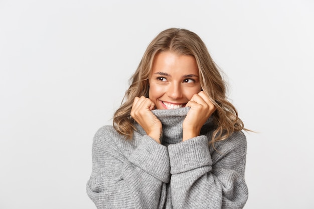 Hermosa mujer en un suéter gris posando