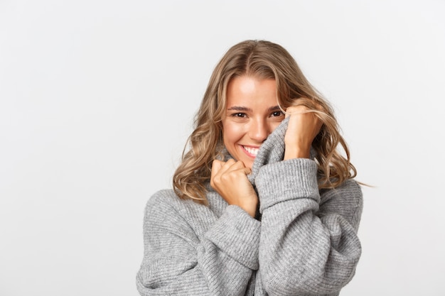 Hermosa mujer en un suéter gris posando