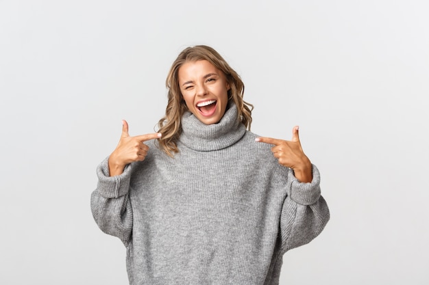 Hermosa mujer en un suéter gris posando