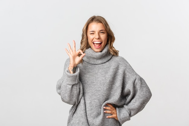 Hermosa mujer en un suéter gris posando