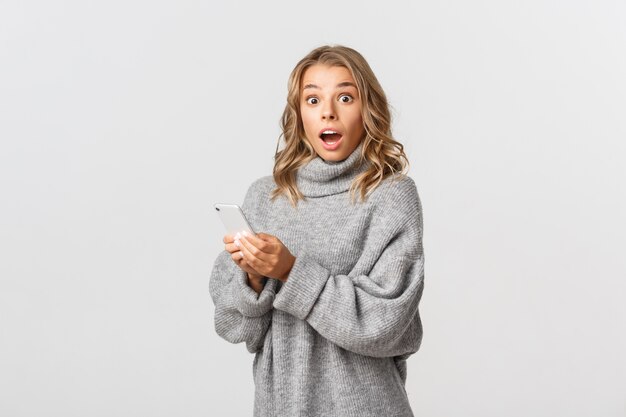 Hermosa mujer en un suéter gris posando