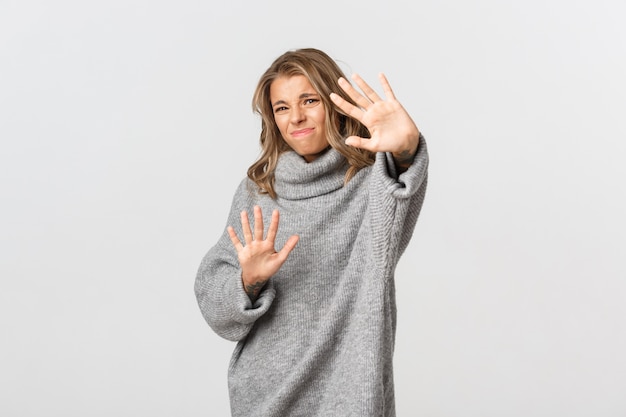 Hermosa mujer en un suéter gris posando