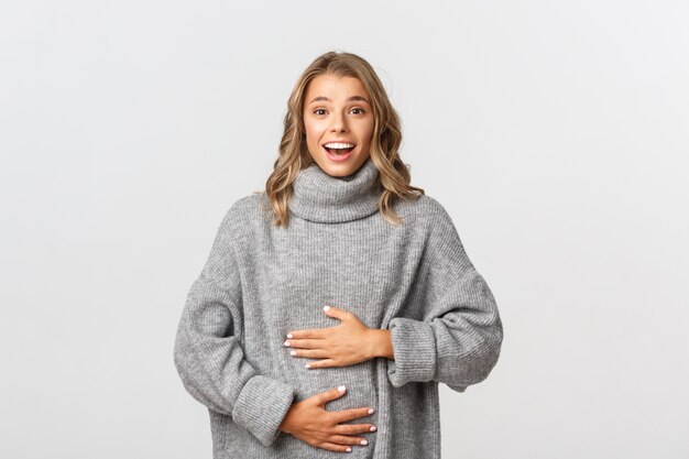 Hermosa mujer en un suéter gris posando